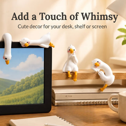 A cozy warm-toned lifestyle image featuring 4 mini duck figurines perched atop a computer screen, a wooden shelf, and a desk setup, with text overlay reading Add a Touch of Whimsy. Cute decor for your desk, shelf or screen.
