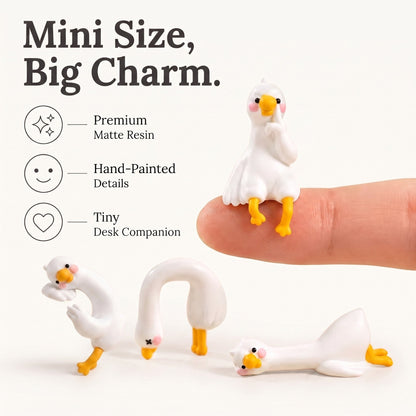 Four miniature white duck figurines with yellow beaks and feet are shown on a clean white background, with one figurine resting on a human finger to demonstrate their tiny scale. The image includes marketing text and icons highlighting premium matte resin, hand-painted details, and tiny desk companion size.