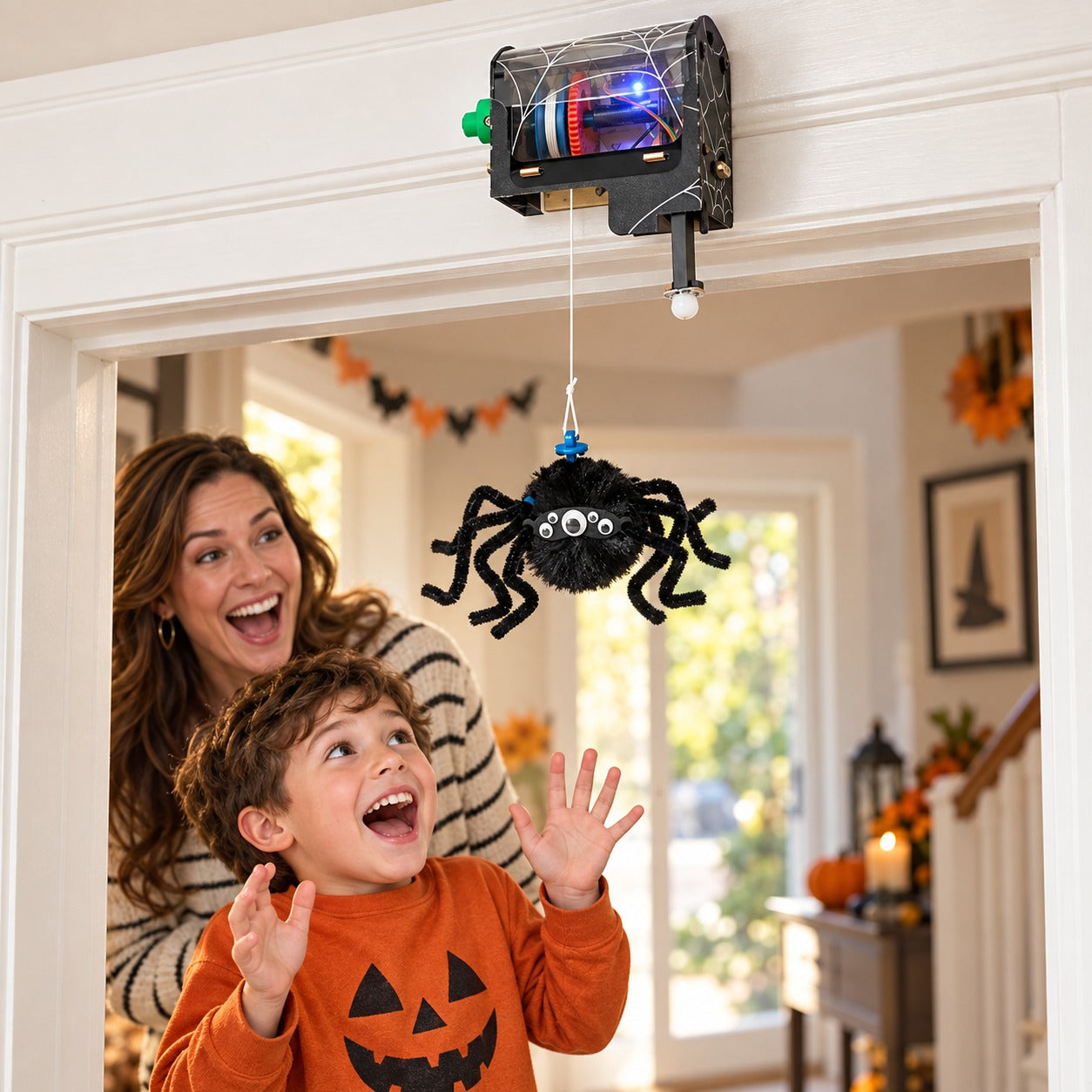 Motion-sensing spider dropping from a doorway as a parent and child laugh